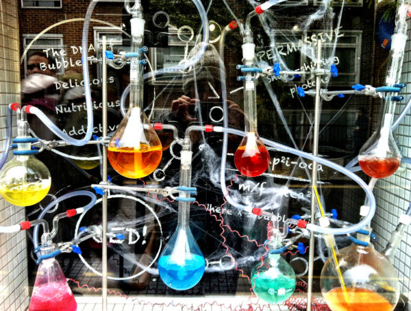 Schaufenster mit verschiedenen Kolben mit unterschiedlich farbigen Flüssigkeiten