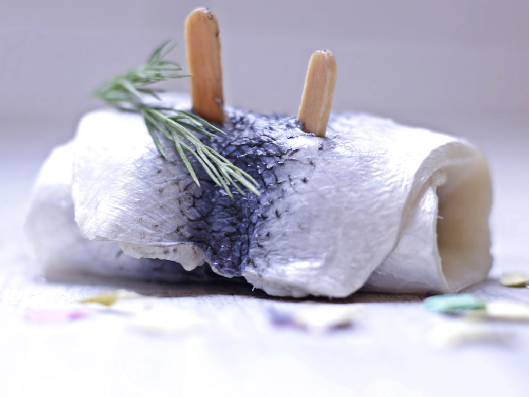 Rollmops mit zwei Holzspießen und Rosmarinzweig