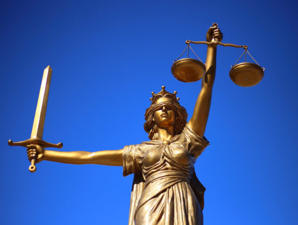 Goldene Justitia vor blauem Hintergrund