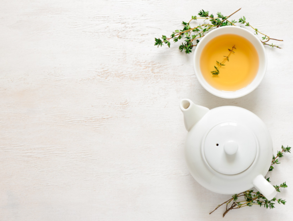 Teekanne und Teetasse auf hellem Holz