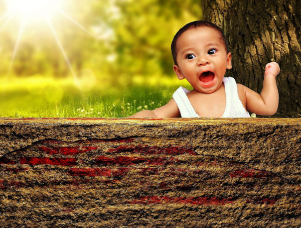 Baby das schimpft und eine Faust ballt hinter einer Mauer.
