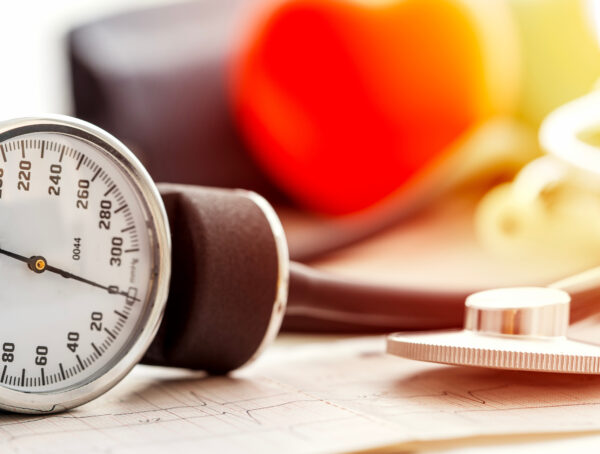 Blutdruck Messgerät und Herz im Hintergrund