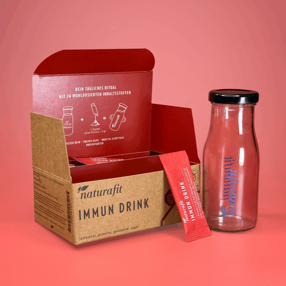 Verpackung naturafit Immun Drink geöffnet, daneben Portionsbeutel und Glasflasche