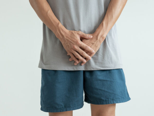 Symbolbild Ein Mann hält sich beide Hände vor den Schritt.