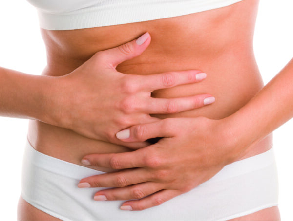 Person legt bei Unwohlsein Hände auf den Bauch, Darstellung von Magenbeschwerden und Blähungen.